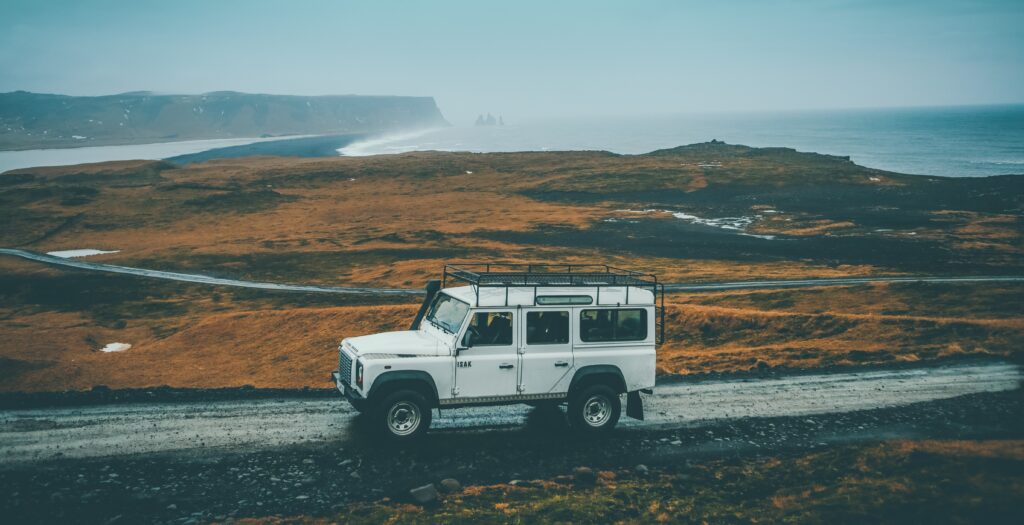 Range Rover Defender in front of a coastal scenery of a rainy day